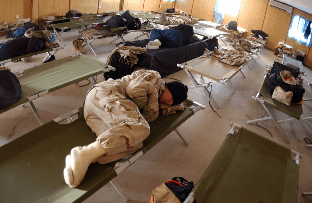 army man sleeping on side in cot